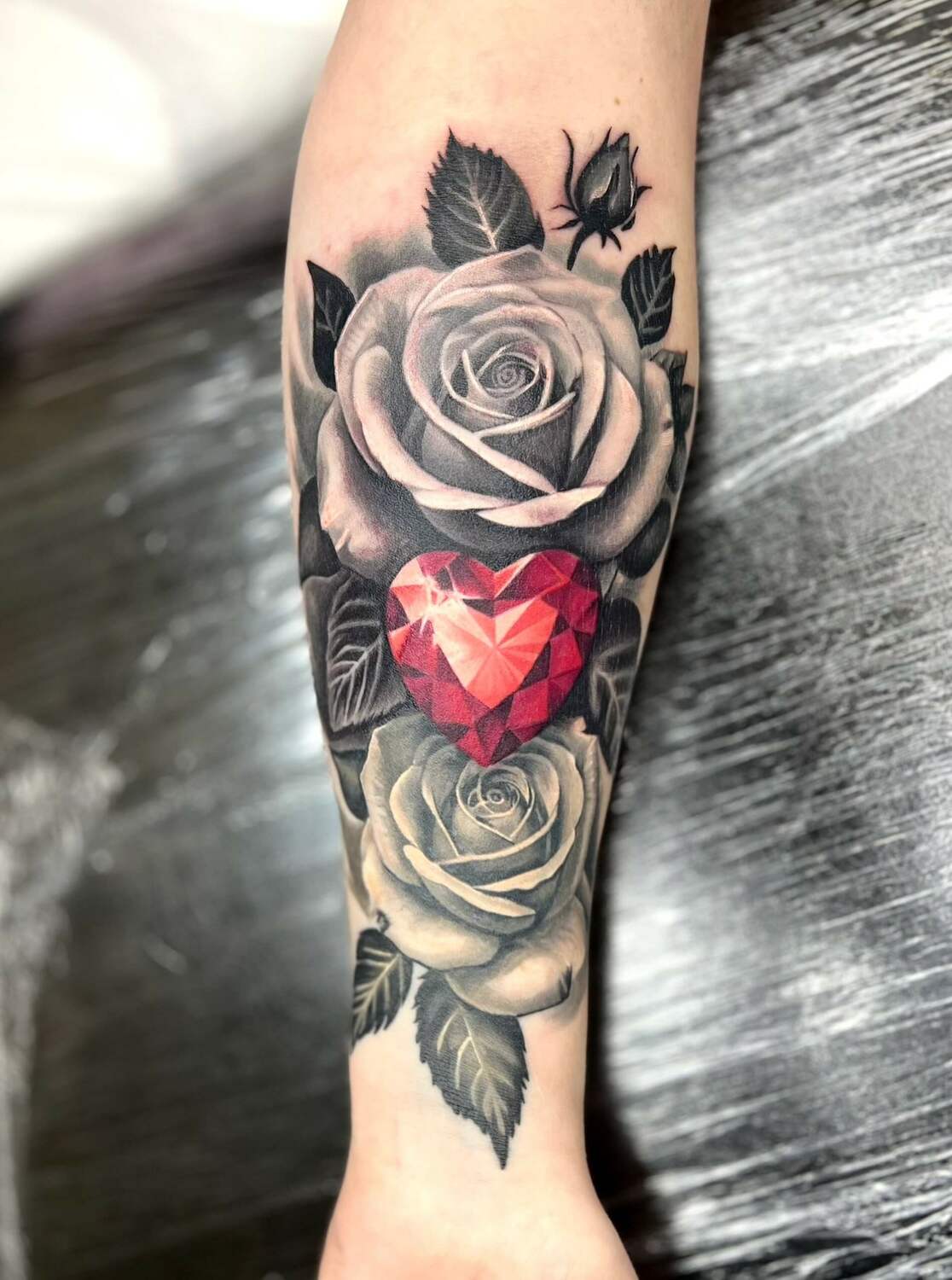 Татуировка с двумя розами и красным сердцем-кристаллом на предплечье