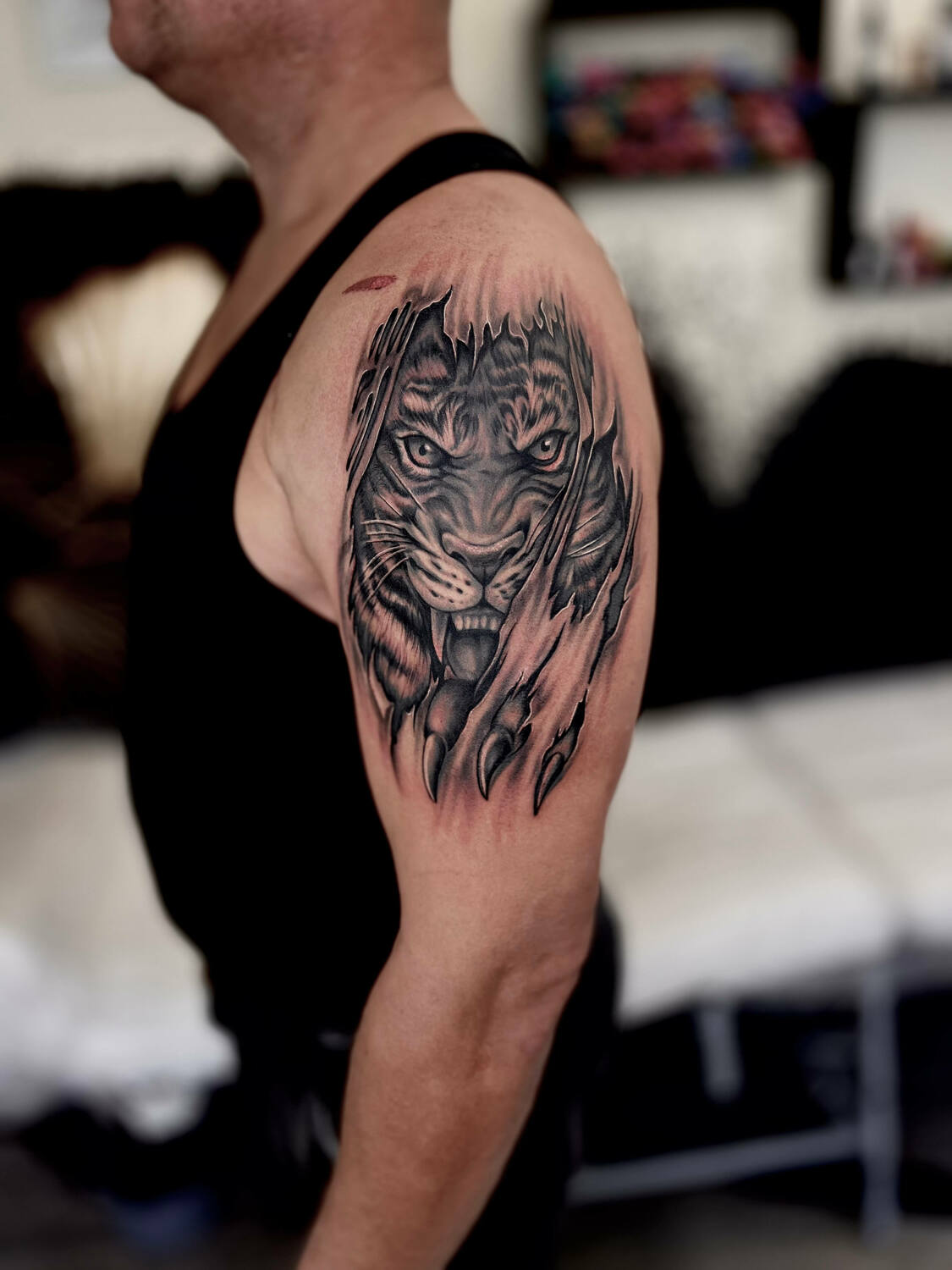 Татуировка тигра в стиле реализм на плече у мужчины