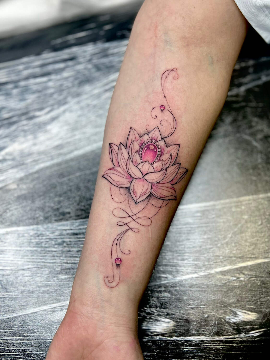 Цветочная татуировка магнолии в розовых оттенках на руке